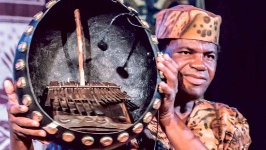 Cosmos Magaya holds up a mbira on stage
