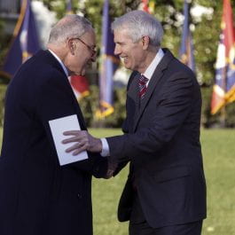 U.S. Senate Majority Leader Charles Schumer (D-NY) (L) shakes hands with Sen. Rob Portman (R-OH) after Portman delivered remarks before President Joe Biden signed the Infrastructure Investment and Jobs Act