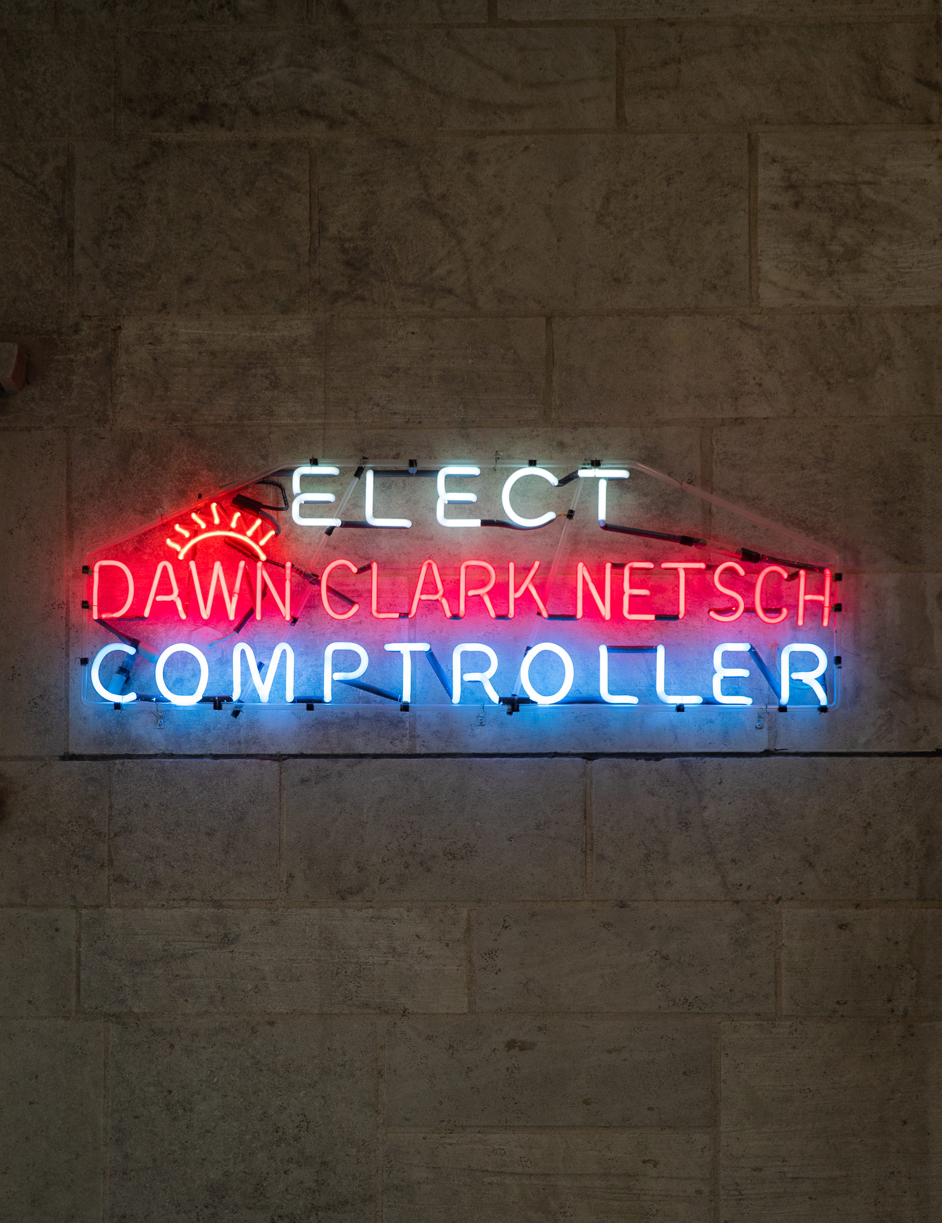 Glowing White, Red, and Blue Neon Sign that reads 'Elect Dawn Clark Netsh Comptroller
