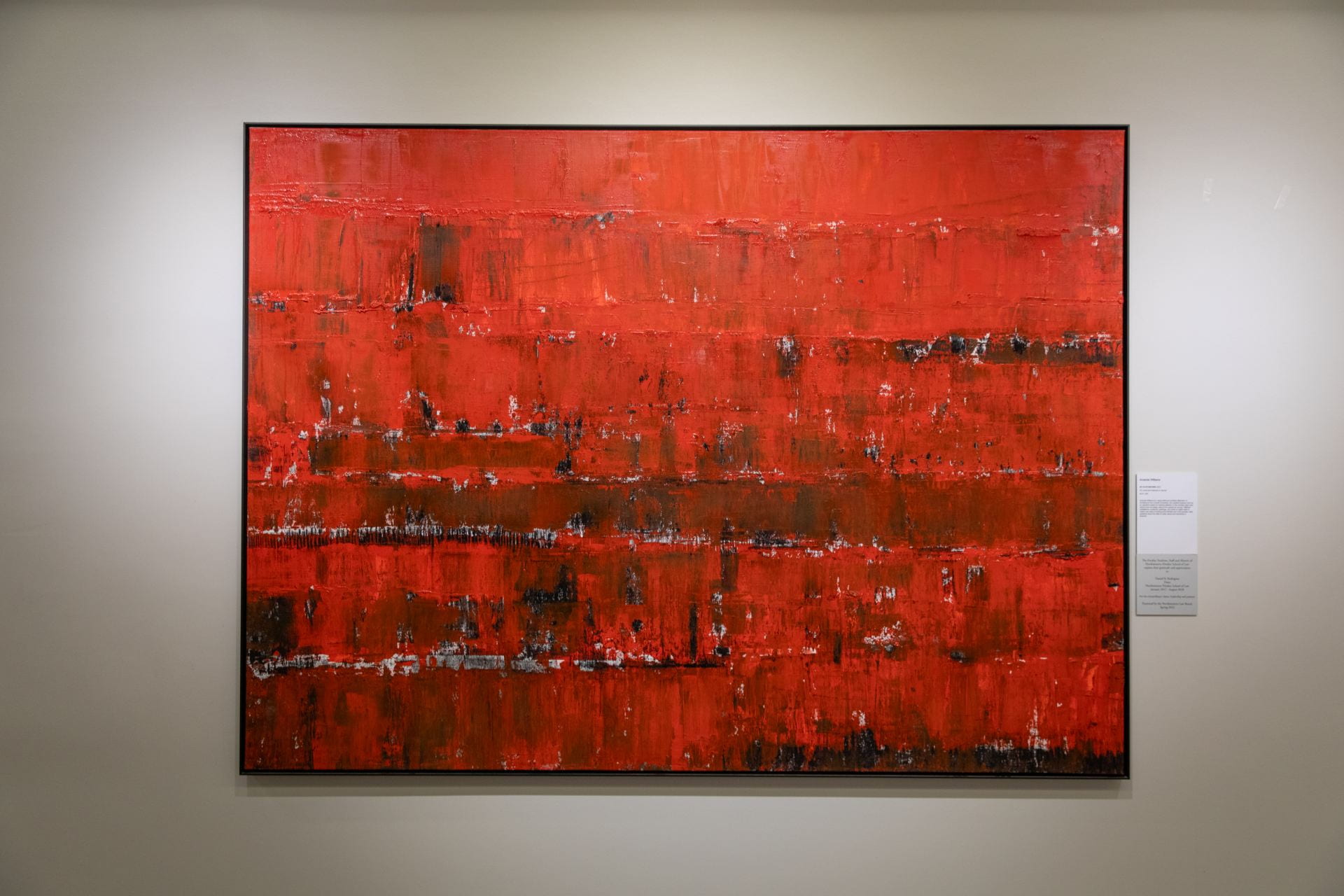 Abstract red painting with black lines and texture etched horizontally across the canvas