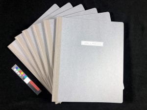 light grey binders spread out on a black background.