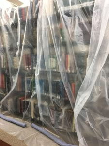 Book shelving unit covered in plastic sheeting