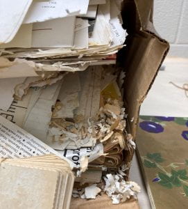 Broken cardboard box with papers falling out