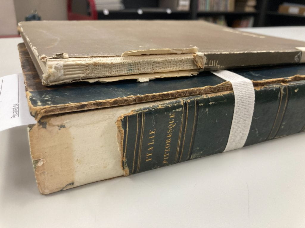 Spines of 2 brownish books laying flat