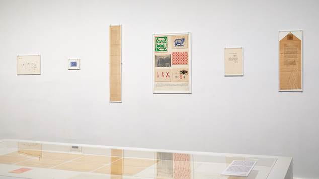six printed objects from Northwestern's Dick Higgins archive hang at an exhibition in the Reina Sofia Museum
