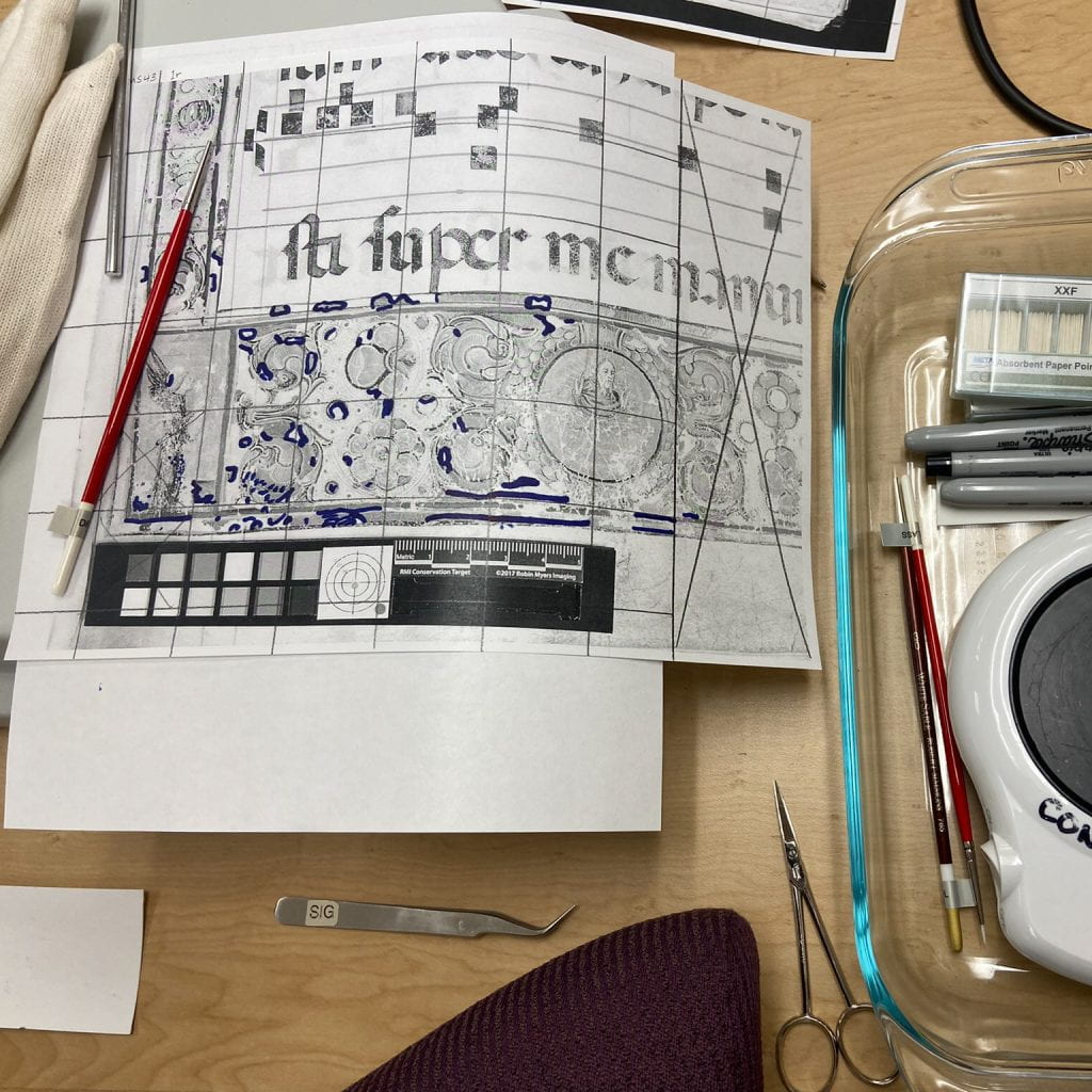 Table with tools, markers, and a schematic of a page with a grid drawn on it