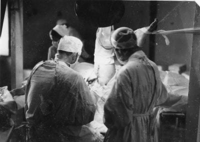 Doctors inserting a Steinman pin through a tibial tuberosity